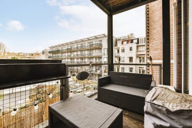 Şık balkon, sokak manzaralı zarif rattan mobilyalar.