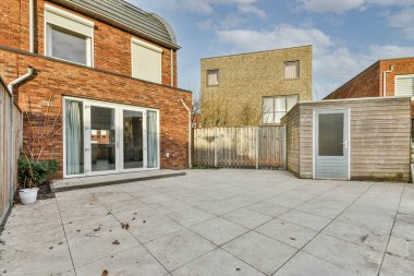 Levhalı, kaldırımlı ve ahşap kapılı bir binanın ön manzarası daireye çıkıyor.