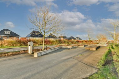 Ağaçlar ve fenerlerle dolu boş bir kaldırım sokağından tuğla evler manzarası