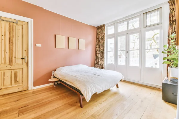 Bright bedroom with wooden door,floor and red walls