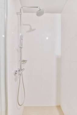Parlak bir banyoda modern duş kabini.