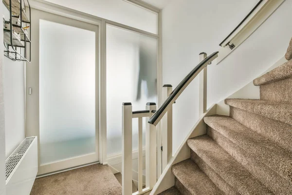 ミニマリストのインテリアデザインのモダンな高級アパートの2階につながる木製の階段付きの白い廊下 — ストック写真