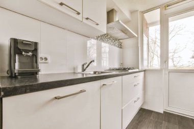 Basit bir mutfak odasında beyaz ahşap mutfak dolapları.