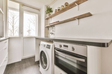 Basit bir mutfak odasında beyaz ahşap mutfak dolapları.