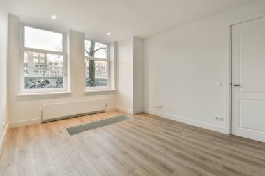 Evdeki boş ışık odasında, beyaz duvardaki plastik pencere ve radyatör.