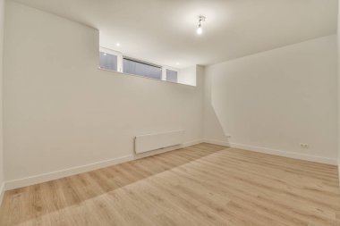 Evdeki boş ışık odasında, beyaz duvardaki plastik pencere ve radyatör.