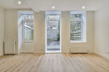 Evdeki boş ışık odasında, beyaz duvardaki plastik pencere ve radyatör.