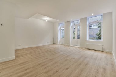 Evdeki boş ışık odasında, beyaz duvardaki plastik pencere ve radyatör.