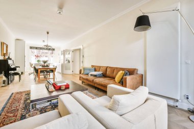 Modern apartmandaki dekorasyonlu ve televizyonlu, rahat koltuğun yanına yerleştirilmiş eski püskü ahşap masa.