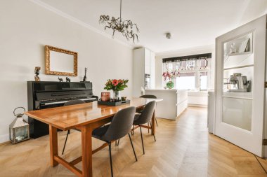 Modern apartmandaki dekorasyonlu ve televizyonlu, rahat koltuğun yanına yerleştirilmiş eski püskü ahşap masa.