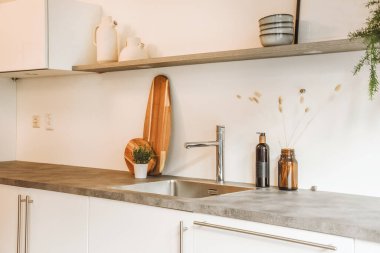 Beyaz mutfak dolabında gümüş bir lavabo var.