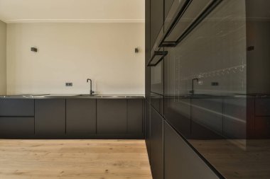 Interior of empty white kitchen with windows and wooden parquet floor