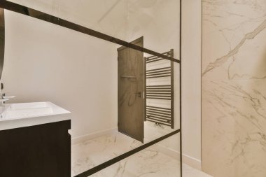 Lavabo ve aynalı dolap kapının yanındaki fayanslı duvara ve modern tuvaletteki kurutma tezgahına bağlı.