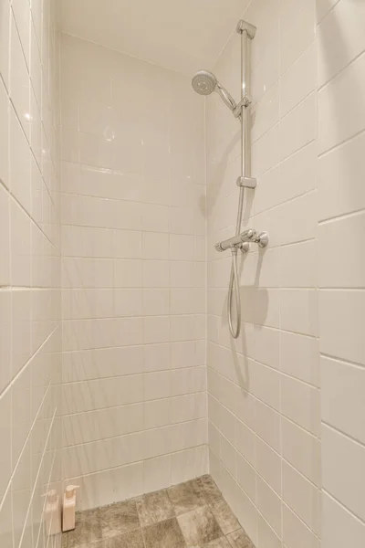 玻璃隔板附近贴在瓷墙上的淋浴水龙头 以及家中卫生间的装饰品 — 图库照片