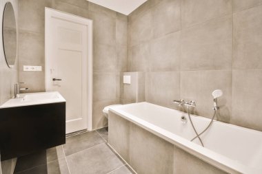 Duşu olan ve düz bir şekilde lavaboya batan çağdaş bir banyo.