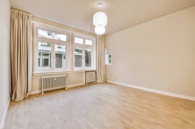 Evdeki boş ışık odasında, beyaz duvardaki plastik pencere ve radyatör.