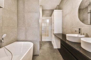 Duşu olan ve düz bir şekilde lavaboya batan çağdaş bir banyo.