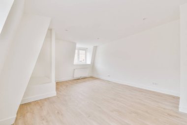 Evdeki boş ışık odasında, beyaz duvardaki plastik pencere ve radyatör.