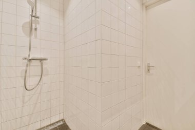 Parlak bir banyoda modern duş kabini.