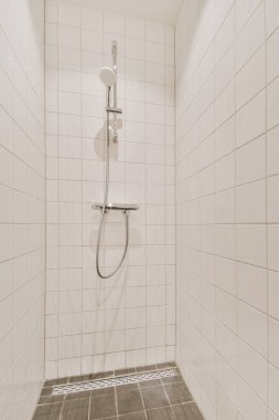 Parlak bir banyoda modern duş kabini.