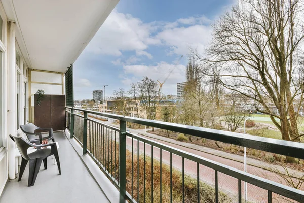 Küçük masası ve sandalyeleri olan bir apartman dairesinin dış görünüşü.