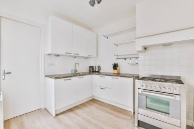 Çağdaş sayaçlar ve tabureler evdeki geniş ışıklı mutfakta şık egzoz kapağının altında.