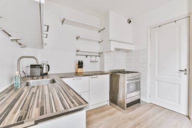 Çağdaş sayaçlar ve tabureler evdeki geniş ışıklı mutfakta şık egzoz kapağının altında.