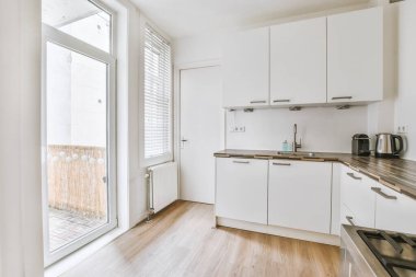 Çağdaş sayaçlar ve tabureler evdeki geniş ışıklı mutfakta şık egzoz kapağının altında.