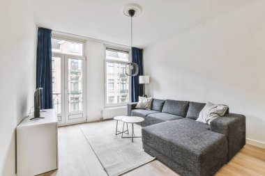 Yastıkları olan rahat bir kanepe. Duvara yaslanmış TV ve dekorasyonlar modern sevgi odasında.