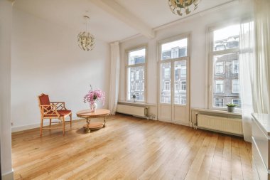 Yumuşak yastıklı rahat bir kanepe şık bir avizenin altında kemerli, ferah bir oturma odasında.