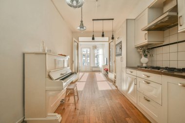 Koridoru ve ahşap parke zemini olan boş beyaz mutfağın içi.