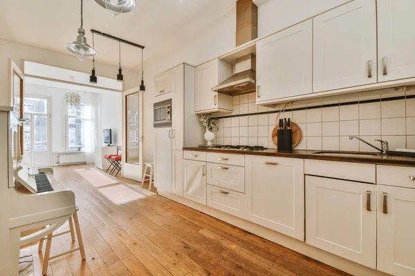 Koridoru ve ahşap parke zemini olan boş beyaz mutfağın içi.