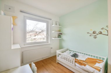 Evinde çeşitli oyuncaklarla dolu rafları ve yatağı olan modern çocuk odası.