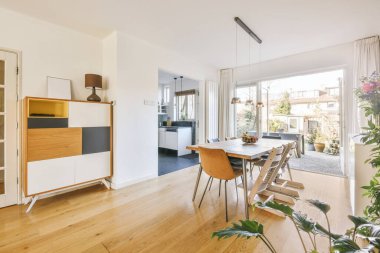 Modern apartmandaki dekorasyonlu ve televizyonlu, rahat koltuğun yanına yerleştirilmiş eski püskü ahşap masa.