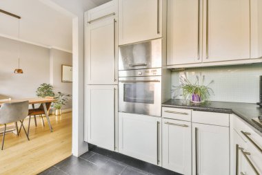 Minimalist tarzı açık mutfağı ve masa ve sandalyeleri olan geniş yemek alanı olan modern çatı katı dairesinin ev tasarımı.