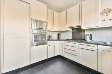 Minimalist tarzı beyaz mobilyalı, lavabolu ve sobalı bir ev mutfağı.