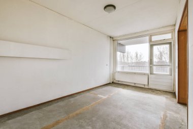 Dekorasyonsuz büyük boş bir odanın içi.