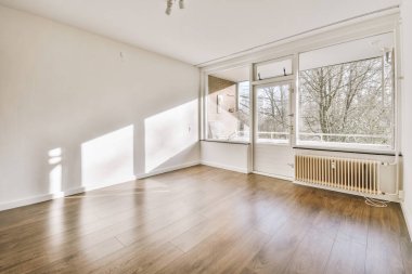 Evdeki boş ışık odasında, beyaz duvardaki plastik pencere ve radyatör.