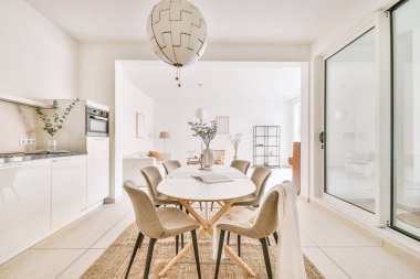 Büyük mutfak odası, beyaz aletler, ahşap beyaz yemek masası ve sandalyeler.