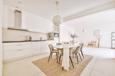 Büyük mutfak odası, beyaz aletler, ahşap beyaz yemek masası ve sandalyeler.