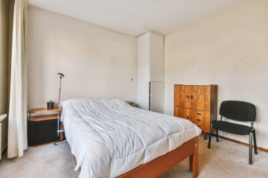 Beyaz battaniyeli, çift tahta yataklı sıradan yatak odası.