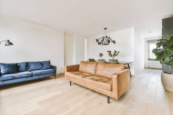 Dark blue and bright brown colored sofas with pillows in the living room