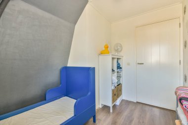 Minimalist bir halısı ve geniş beyaz penceresi olan ferah, parlak bir yatak odası.