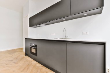 Minimalist tarzı beyaz mobilyalı, lavabolu ve sobalı siyah ev mutfağı.