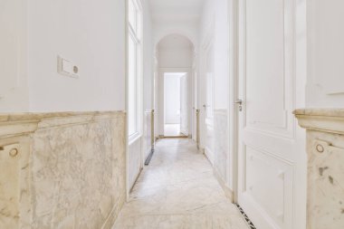 Dar, boş koridor lambalarla aydınlatılmış, minimal tarzda modern dairenin içi