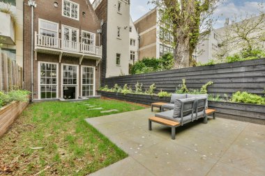 Açık hava eğlencesi için yemek alanı olan minimalist, parlak ve manzaralı bir arka bahçe.