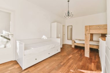 Geniş beyaz yatak odası, yataklar, zarif avize ve parke zemin.