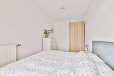 Yatak odasının iç tasarımı, yatak odası ve ahşap gardırop modern dairenin penceresinin kenarına yerleştirilmiş.