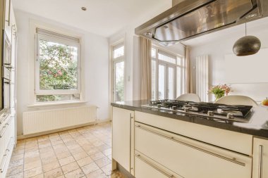 Tezgahlı açık mutfak tasarımı ve tavanın altında kapüşonlu bir ada.