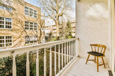 Korkuluklu küçük bir balkondan ağaçlı tuğla binaların panoramik manzarası